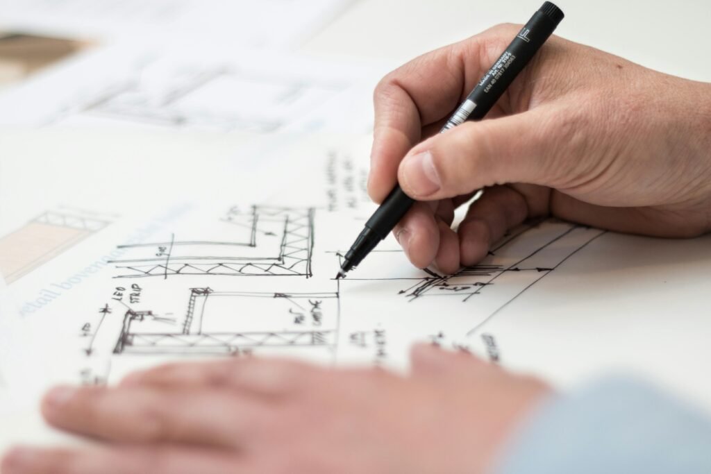 pexels photo 1109541 1109541 Close-up of hand drawing intricate technical designs on blueprint with pen, ideal for engineering or architecture themes.